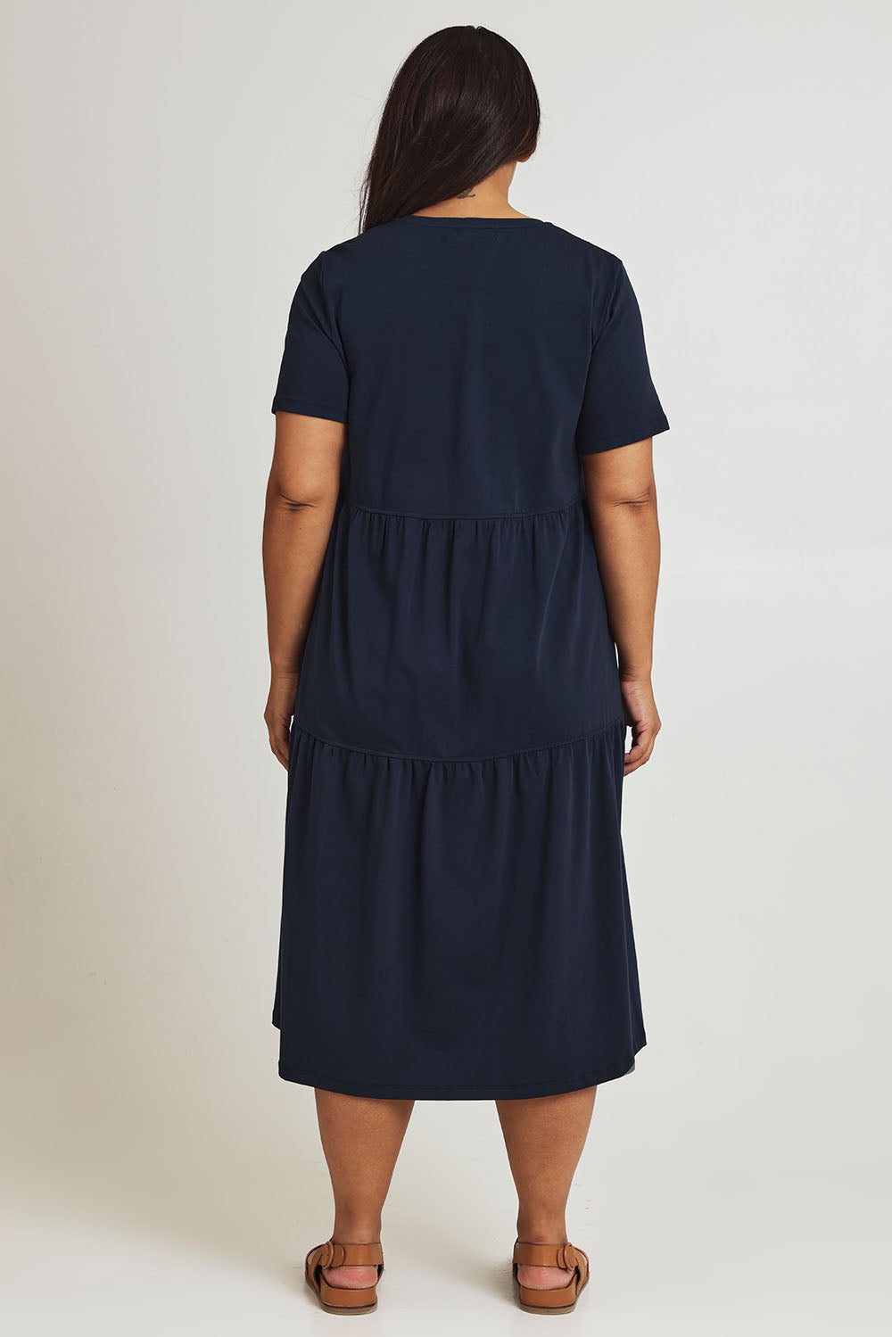 Model Ashleigh wearing size 16 of The Tiered Jersey Dress in colour Navy (Blue), from the back