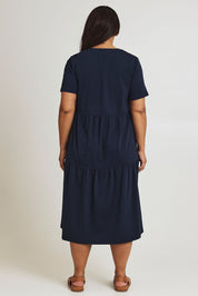 Model Ashleigh wearing size 16 of The Tiered Jersey Dress in colour Navy (Blue), from the back