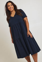 Model Ashleigh wearing size 16 of The Tiered Jersey Dress in colour Navy (Blue), from the front, cropped image