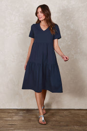 Model Madeline wearing size 10 of The Tiered Jersey Dress in colour Navy (Blue), from the front, showing the whole outfit