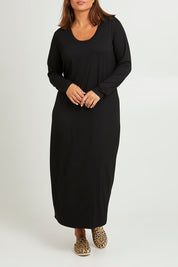 Model Monique wearing size 14 of The Long Sleeve Bamboo Dress in colour Black (Black), from the front, cropped image