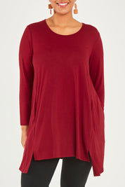 Model Noli wearing size 14 of The Crew Neck High Low Tunic in colour Redberry (Red), from the front, cropped image