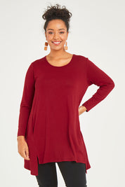 Model Noli wearing size 14 of The Crew Neck High Low Tunic in colour Redberry (Red), from the front, cropped image