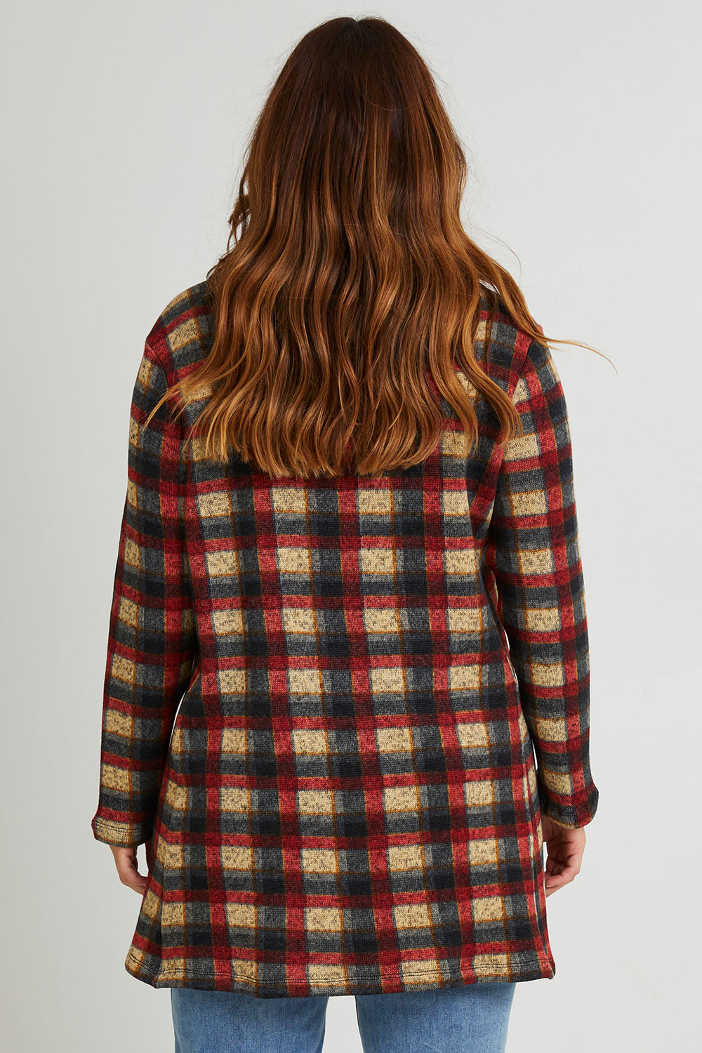 Model Laura wearing size 14 of The Woolly Knit High Low Tunic in colour Navycheck (Blue), from the back