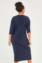 Model Noli wearing size 14 of The Recycled Everyday V Neck Dress in colour Navy (Blue), from the back