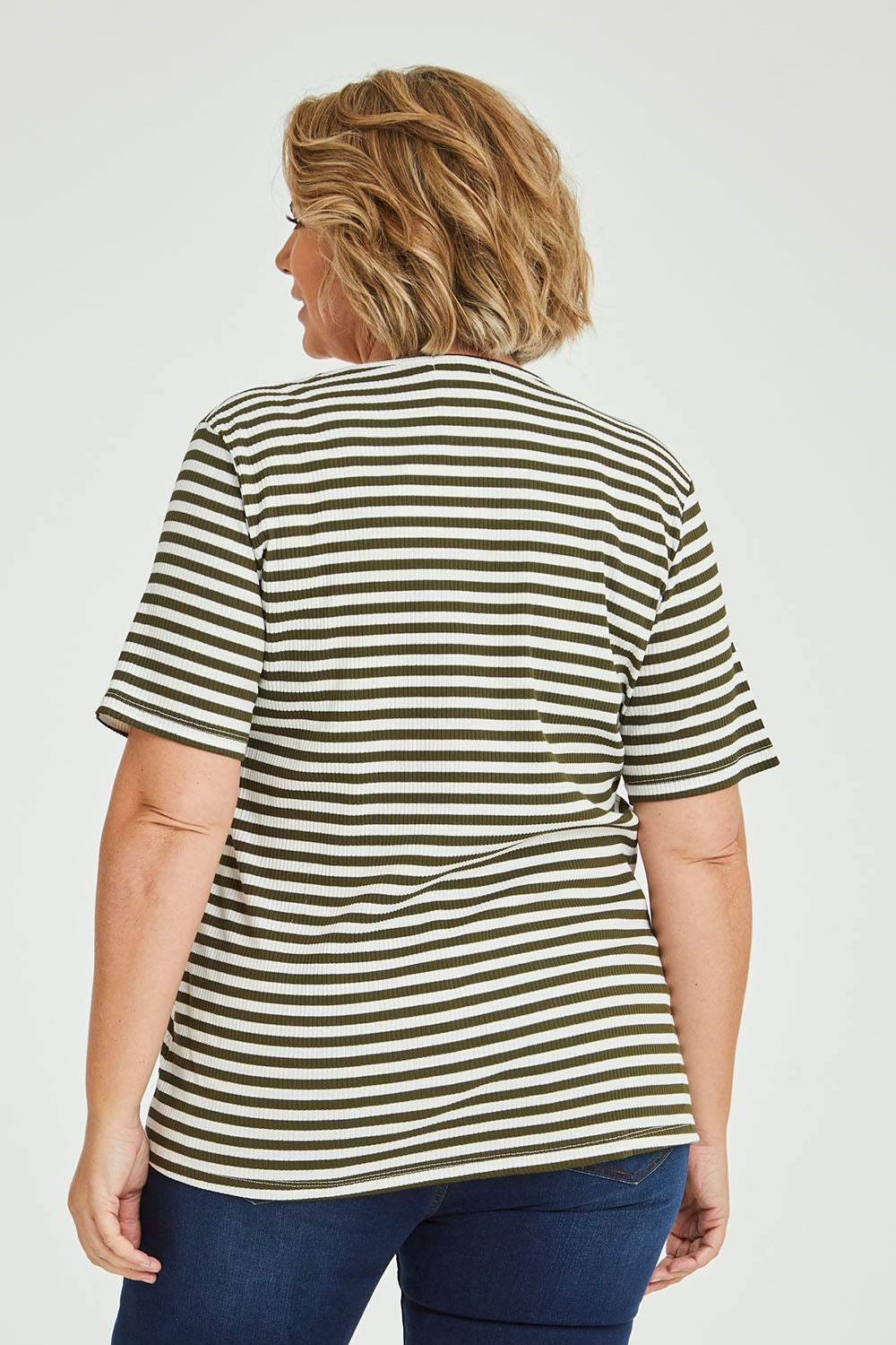 Model Fiona wearing size 16 of The Spliced Stripe Tee in colour Olive (Green), from the back