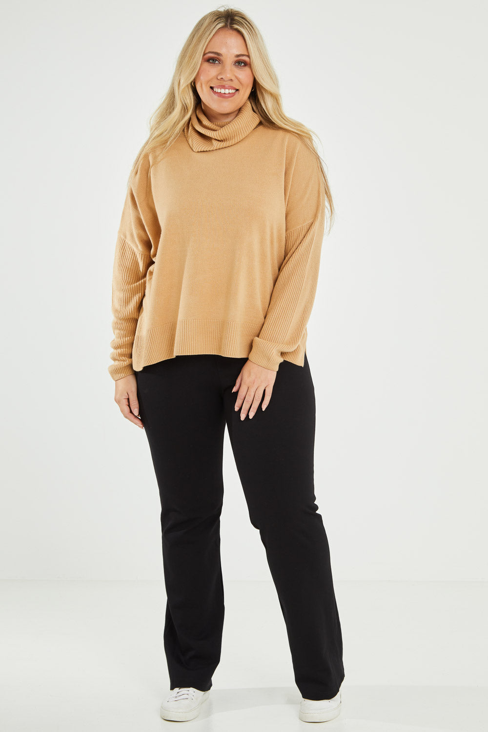 Model Katie wearing size XL of The Essential Soft High Low Jumper in colour Camel, from the front, showing the whole outfit