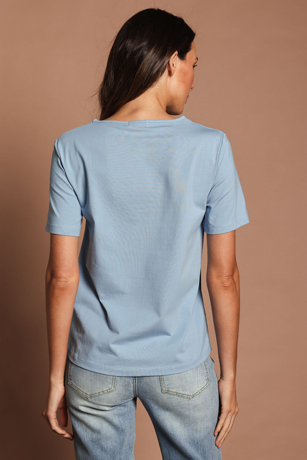 Model Madeline wearing size 10 of The Keepers Tee in colour Dustyblue (Blue), from the back