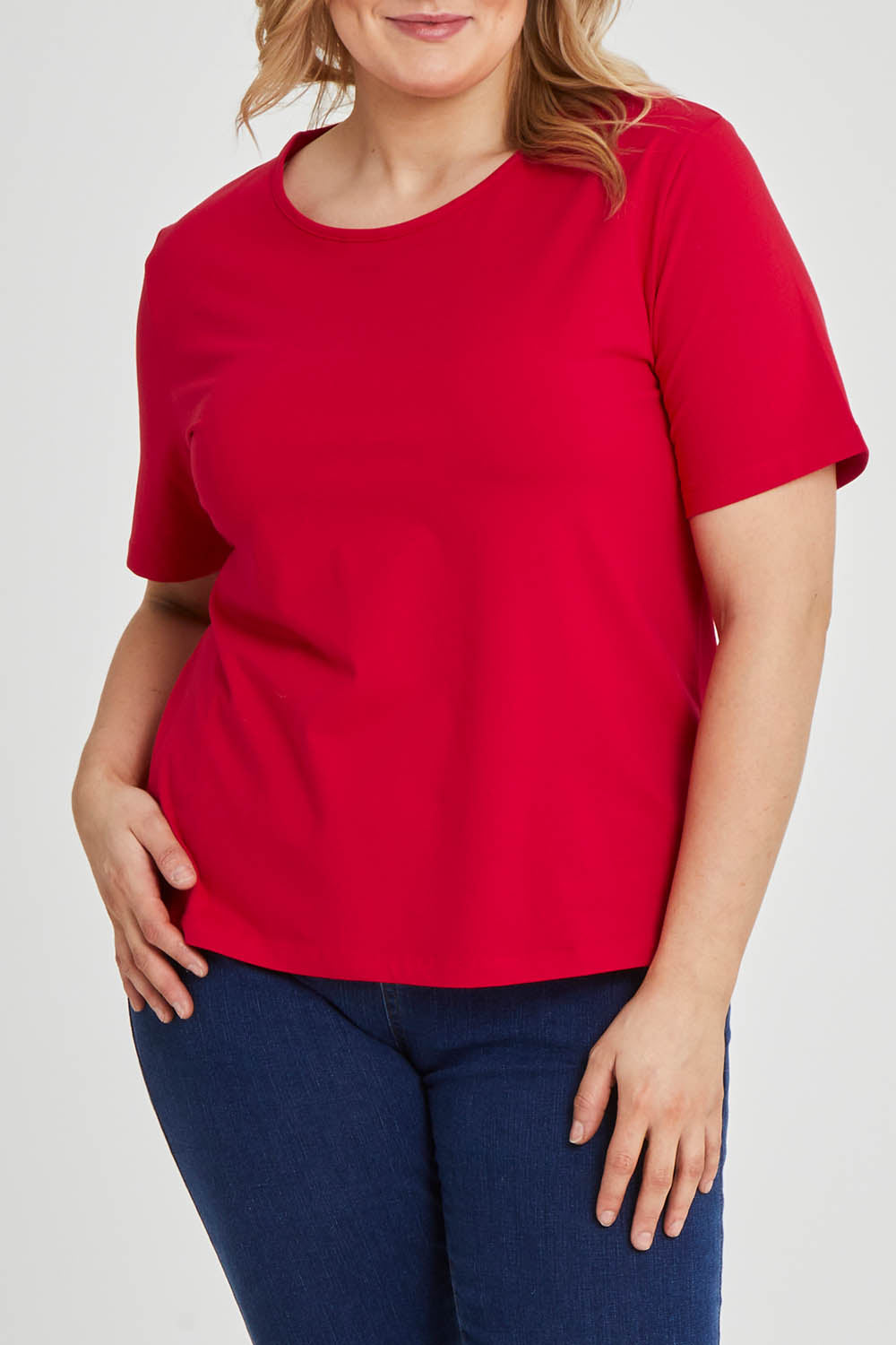 Model Keeara wearing size 16 of The Keepers Tee in colour Red (Red), from the front, cropped image