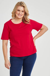 Model Keeara wearing size 16 of The Keepers Tee in colour Red (Red), from the front, cropped image