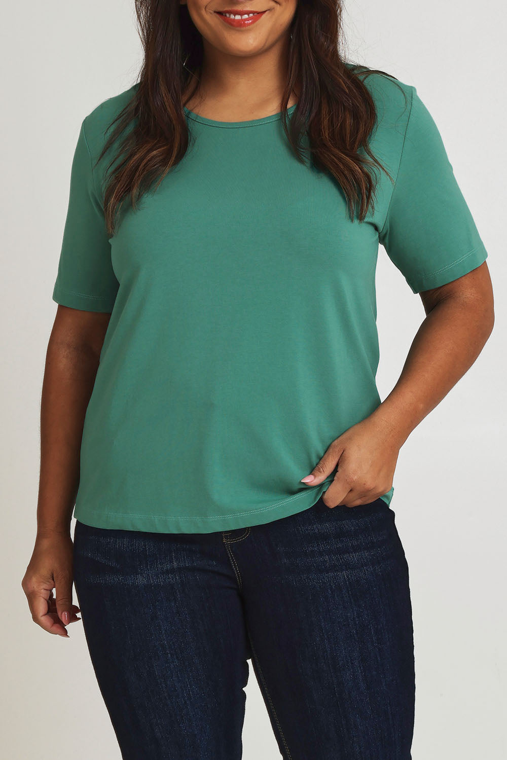 Model Ashleigh wearing size 16 of The Keepers Tee in colour Seagreen (Green), from the front, cropped image