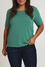 Model Ashleigh wearing size 16 of The Keepers Tee in colour Seagreen (Green), from the front, cropped image