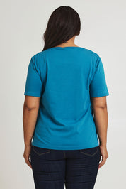 Model Ashleigh wearing size 16 of The Keepers Tee in colour Turquoise (Blue), from the back