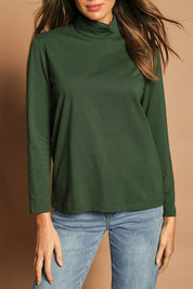 Model Madeline wearing size 10 of The Keepers Skivvy in colour Pinegreen (Green), from the front, cropped image