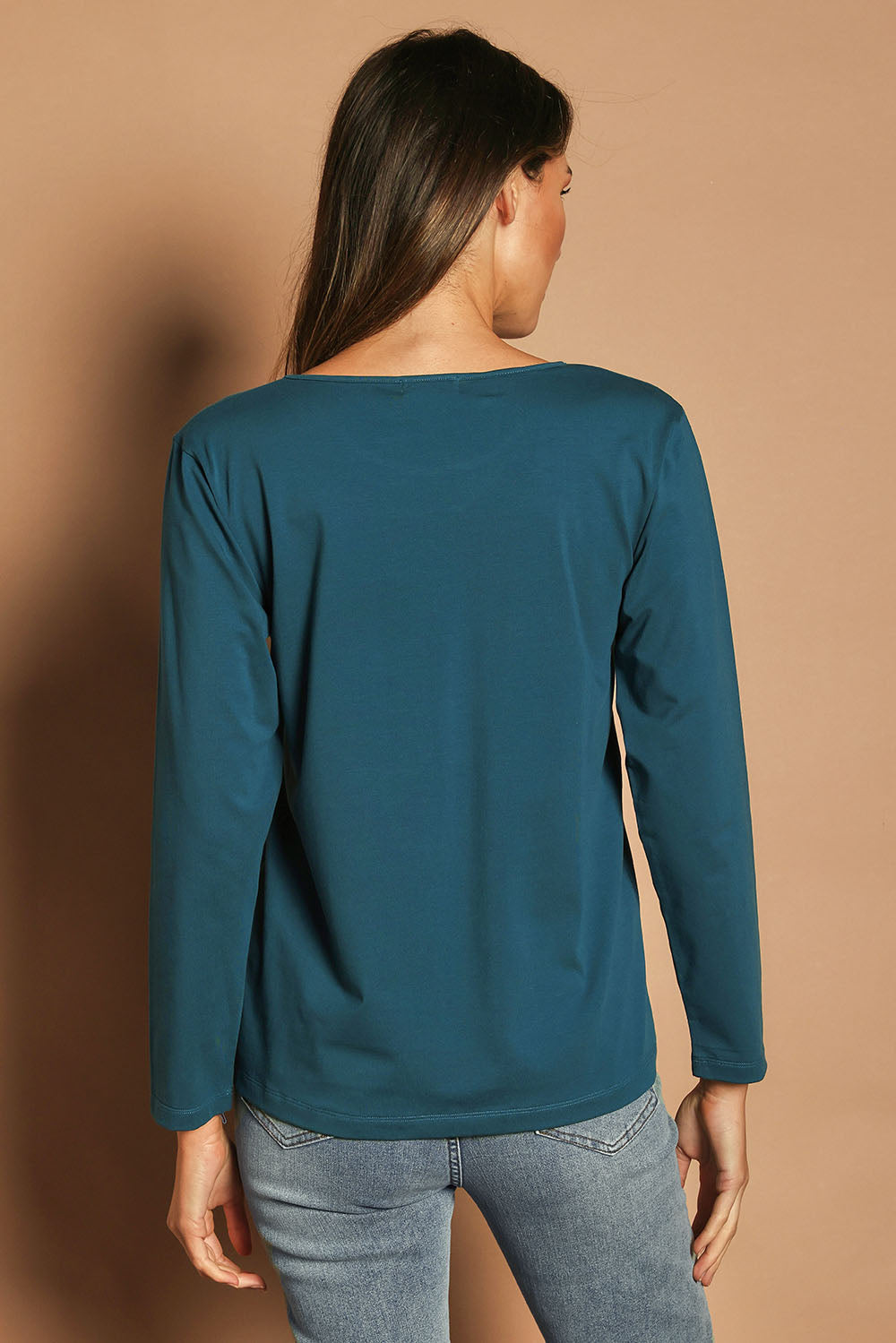 Model Madeline wearing size 10 of The Keepers Long Sleeve Tee in colour Opal (Blue), from the back