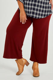 Model Alexis wearing size 16 of The Recycled Wide Leg Pant in colour Terracotta, from the front, cropped image