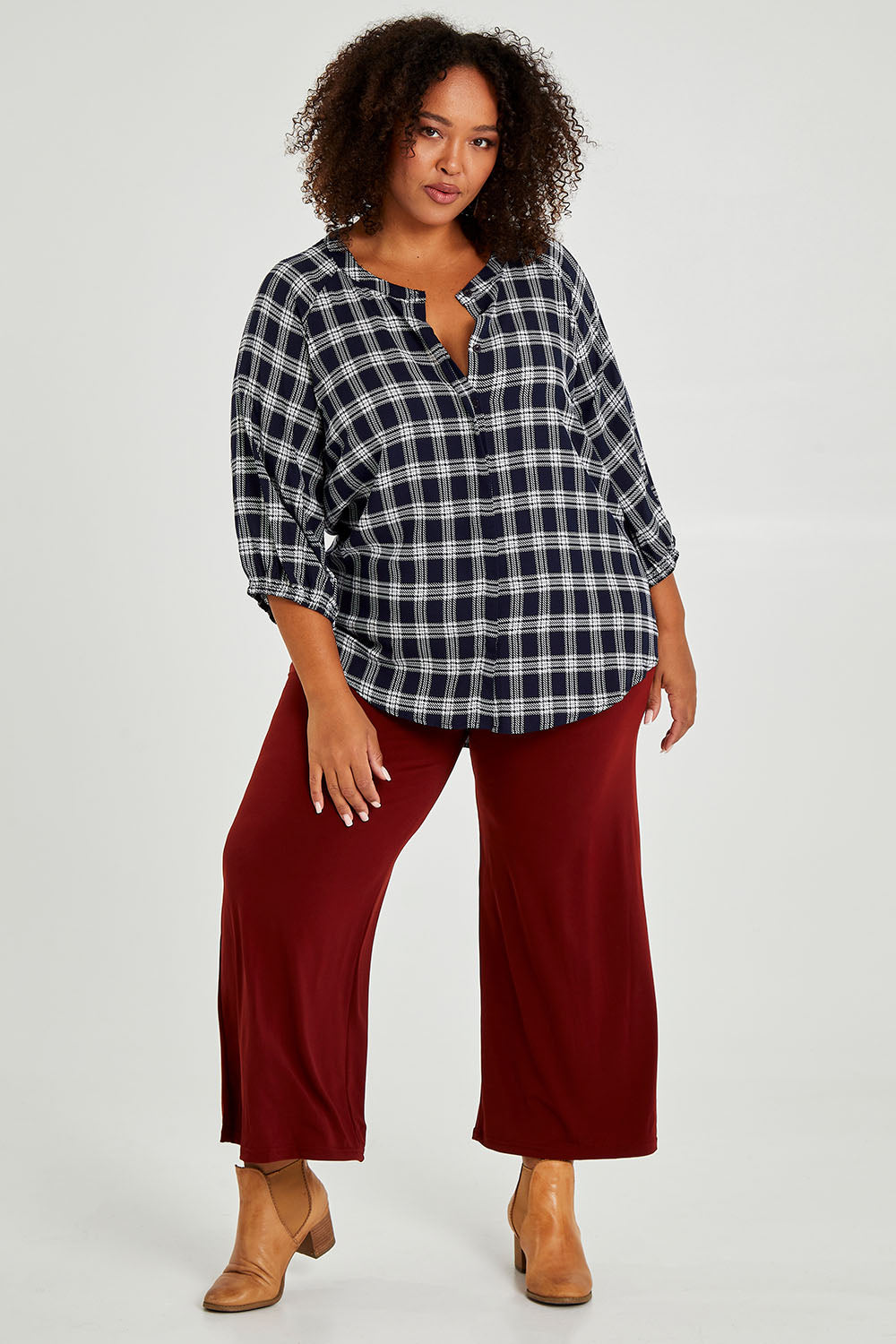 Model Alexis wearing size 16 of The Recycled Wide Leg Pant in colour Terracotta, from the front, showing the whole outfit