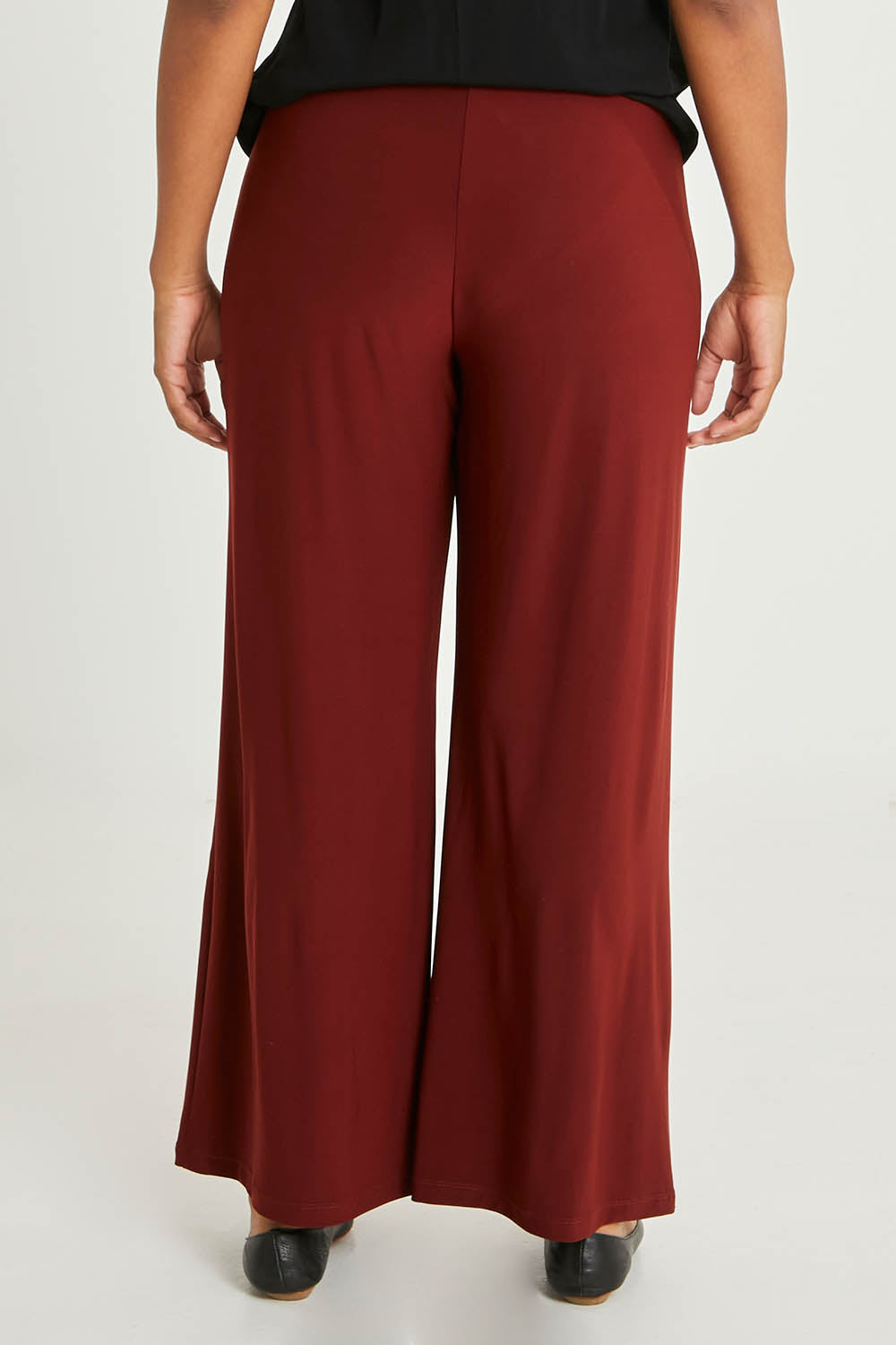 Model Noli wearing size 14 of The Recycled Wide Leg Pant in colour Terracotta, from the back