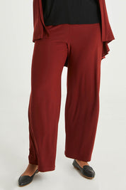 Model Noli wearing size 14 of The Recycled Wide Leg Pant in colour Terracotta, from the front, cropped image