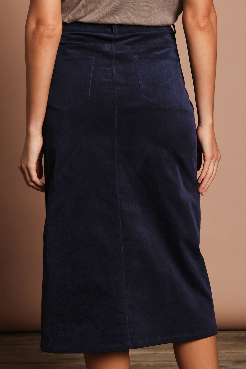 Model Madeline wearing size 10 of The 5 Pocket Cord Midi Skirt in colour Darknavy (Blue), from the back