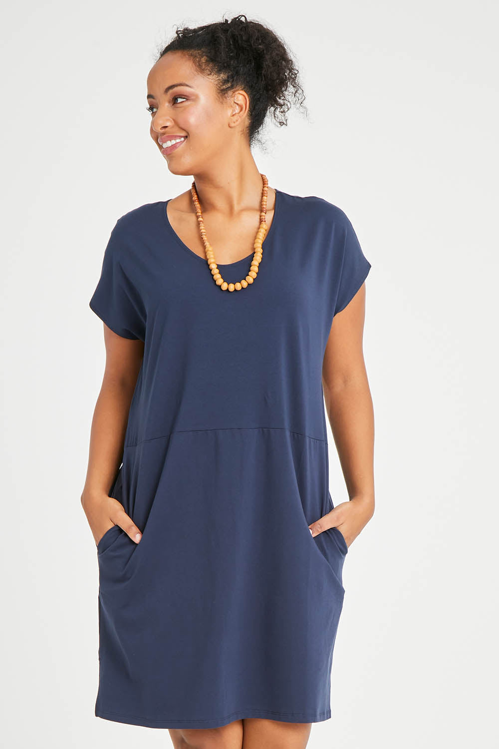 Model Noli wearing size 14 of The Luxe Cotton Tee Dress in colour Navy (Blue), from the front, cropped image