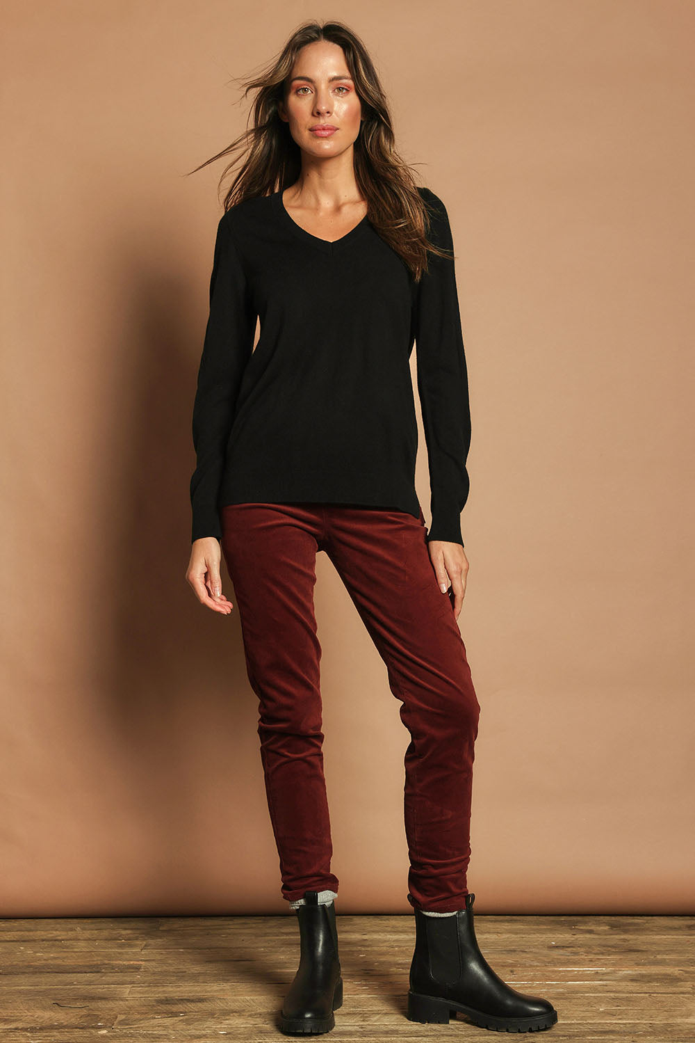Model Madeline wearing size S of The Keepers Soft V Neck Jumper in colour Black (Black), from the front, showing the whole outfit