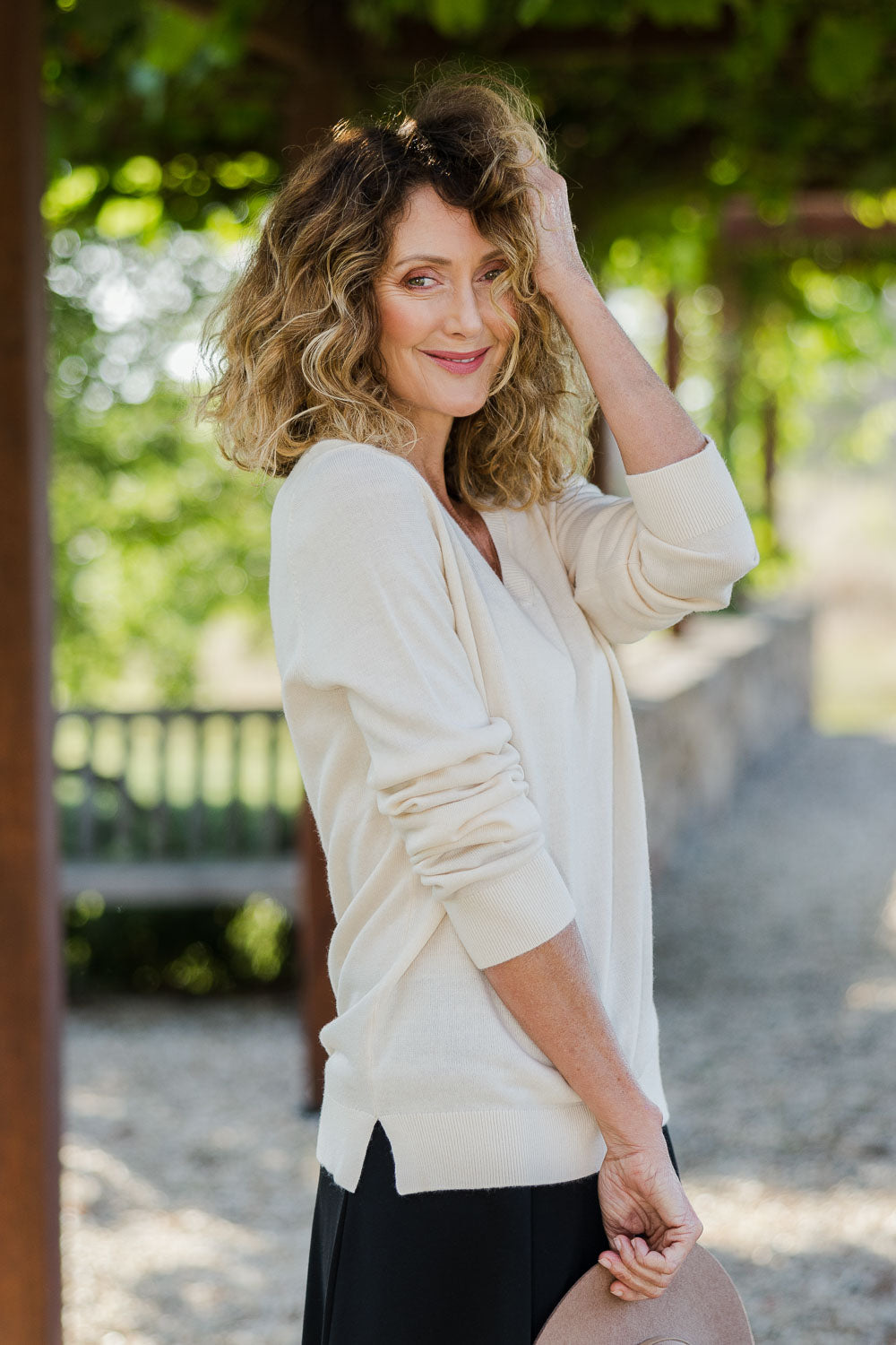 Model Emma wearing size S of The Keepers Soft V Neck Jumper in colour Ivory (White), from the front, showing the whole outfit