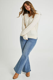 Model Laura wearing size L of The Keepers Soft V Neck Jumper in colour Ivory (White), from the front, showing the whole outfit