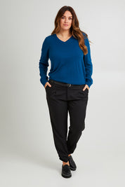 Model Laura wearing size L of The Keepers Soft V Neck Jumper in colour Petrol (Blue), from the front, showing the whole outfit