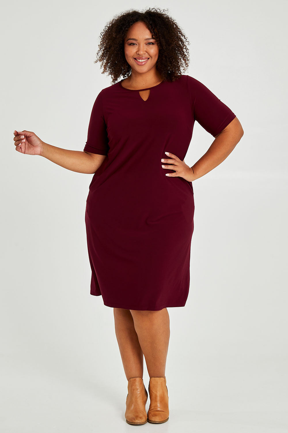 Model Alexis wearing size 16 of The Recycled Easy Wear Keyhole Dress in colour Burgundy (Purple), from the front, showing the whole outfit