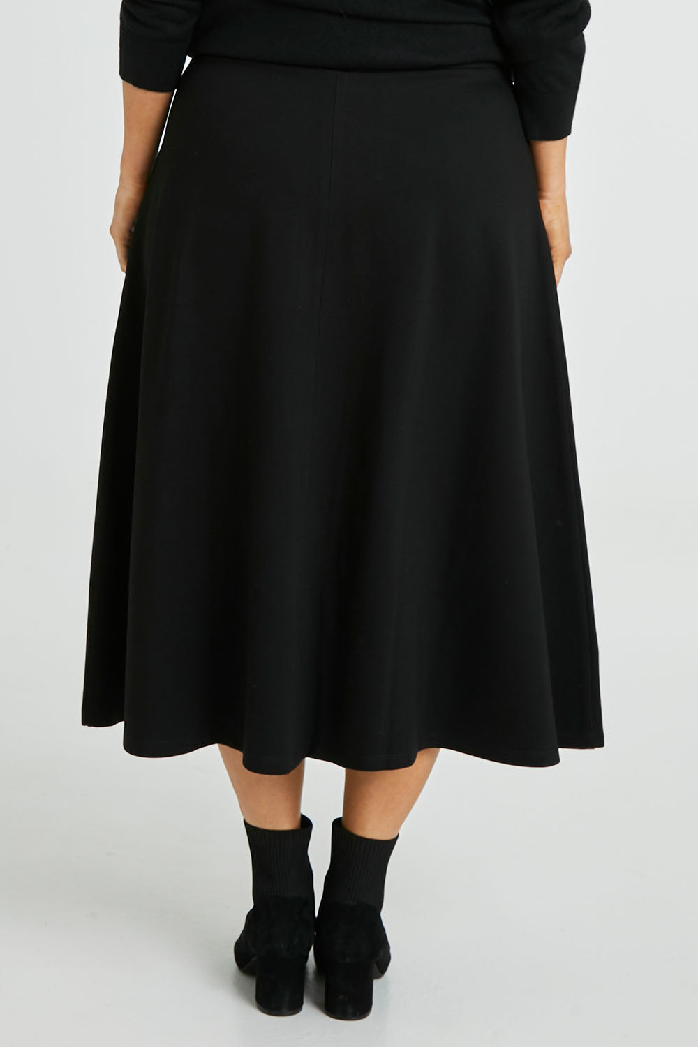 Model Laura wearing size 14 of The Fit And Flare Ponte Skirt in colour Black (Black), from the back