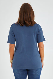 Model Monique wearing size L of The Transeasonal Short Sleeve Jumper in colour Blueberry (Blue), from the back