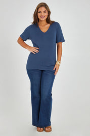 Model Monique wearing size L of The Transeasonal Short Sleeve Jumper in colour Blueberry (Blue), from the front, showing the whole outfit