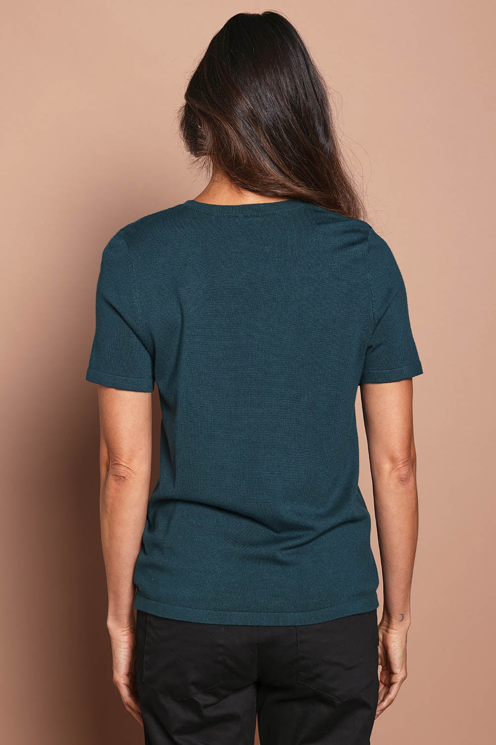 Model Amanda wearing size S of The Transeasonal Short Sleeve Jumper in colour Peacock (Green), from the back