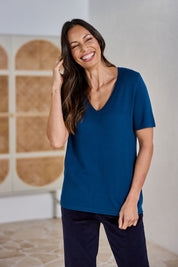 Model Amanda wearing size S of The Transeasonal Short Sleeve Jumper in colour Petrol (Blue), from the front, showing the whole outfit