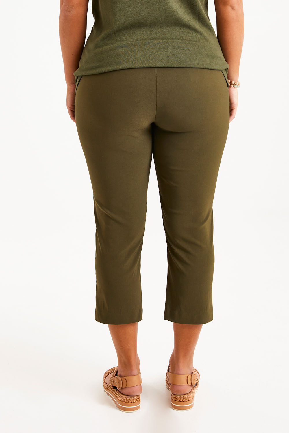Model Monique wearing size 14 of The Contour Capri Pant in colour Olive (Green), from the back