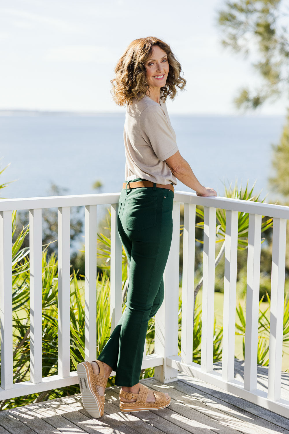 Model Emma wearing size 10 of The Stretch Coloured Denim Jean in colour Peacock (Blue), from the back