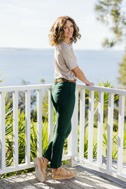 Model Emma wearing size 10 of The Stretch Coloured Denim Jean in colour Peacock (Blue), from the back