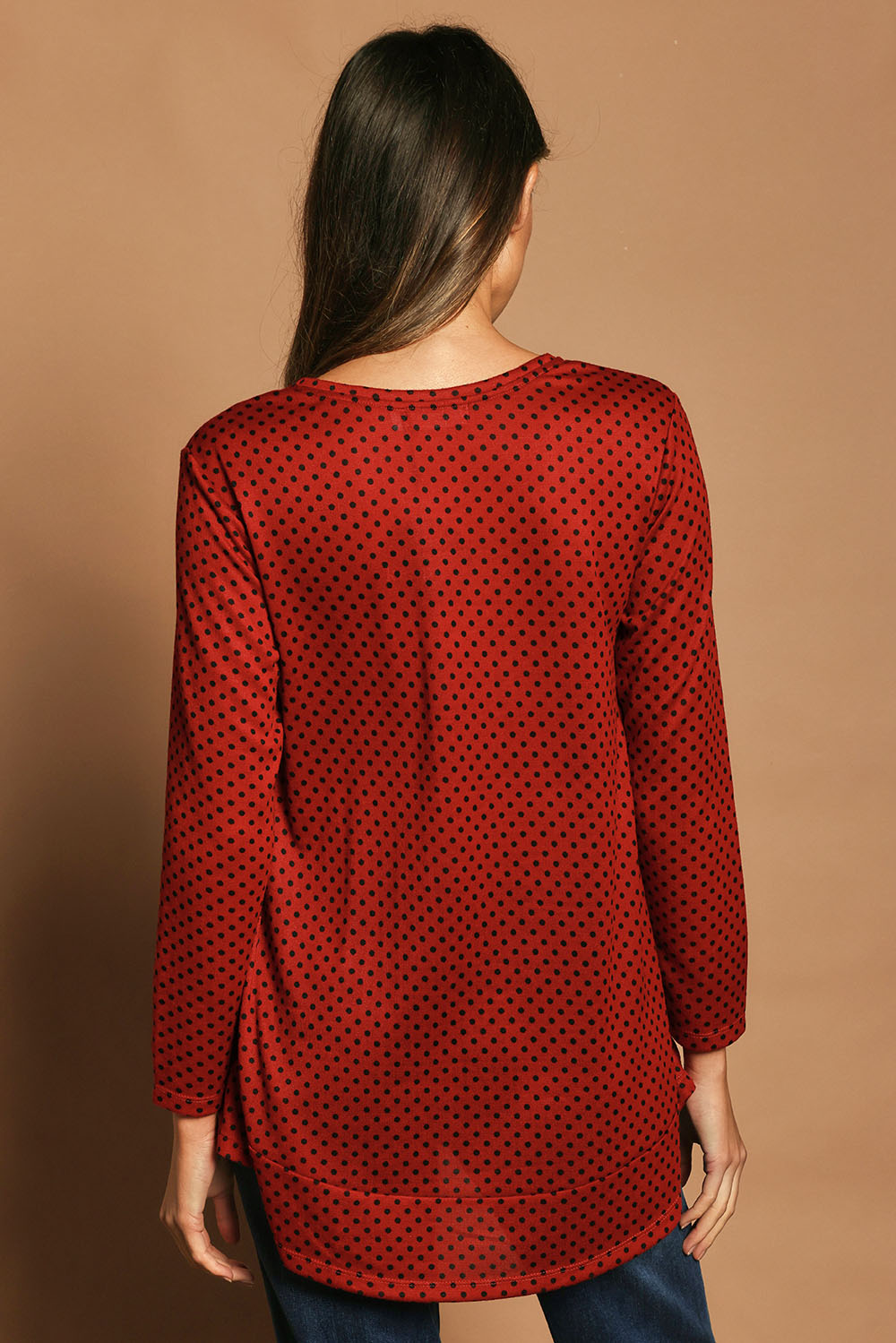Model Madeline wearing size 10 of The Spot Swing Knit Tee in colour Burntred (Red), from the back