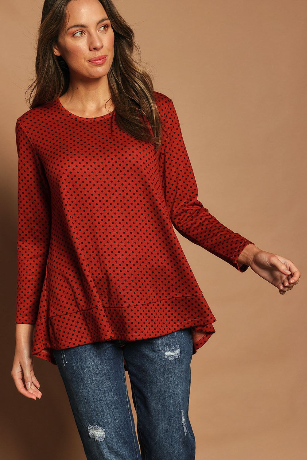 Model Madeline wearing size 10 of The Spot Swing Knit Tee in colour Burntred (Red), from the front, cropped image