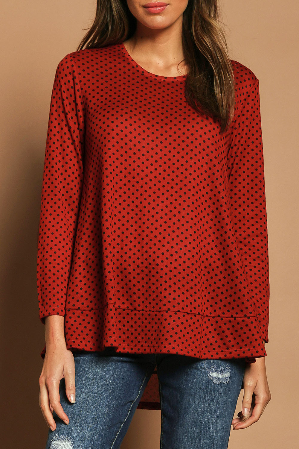 Model Madeline wearing size 10 of The Spot Swing Knit Tee in colour Burntred (Red), from the front, cropped image