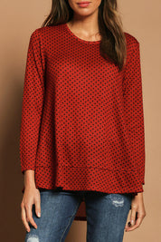 Model Madeline wearing size 10 of The Spot Swing Knit Tee in colour Burntred (Red), from the front, cropped image