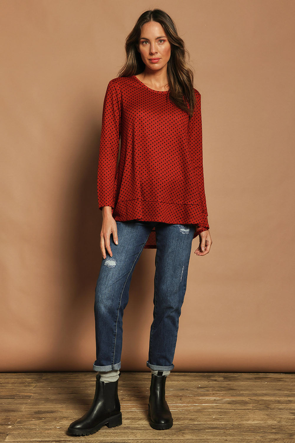 Model Madeline wearing size 10 of The Spot Swing Knit Tee in colour Burntred (Red), from the front, showing the whole outfit