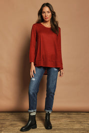 Model Madeline wearing size 10 of The Spot Swing Knit Tee in colour Burntred (Red), from the front, showing the whole outfit