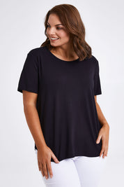 Model Monique wearing size 14 of The Bamboo Curved Hem Tee in colour Black (Black), from the front, cropped image
