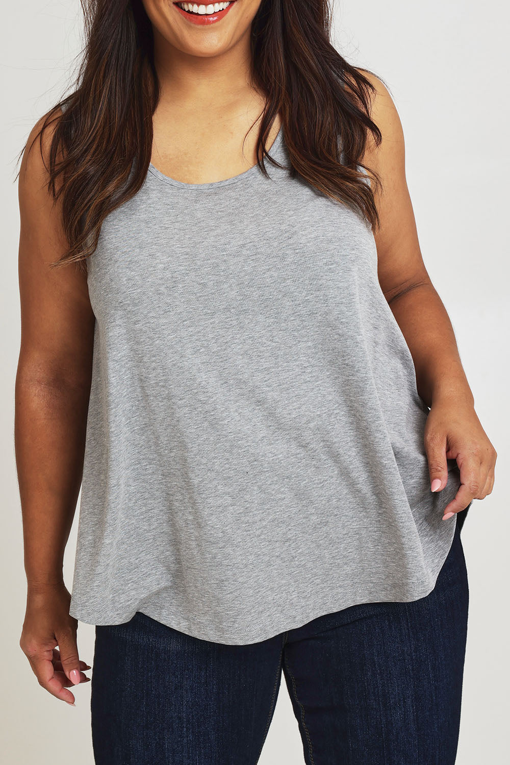 Model Ashleigh wearing size 16 of The Bamboo Crew Neck Swing Tank in colour Greymarle (Grey), from the front, cropped image
