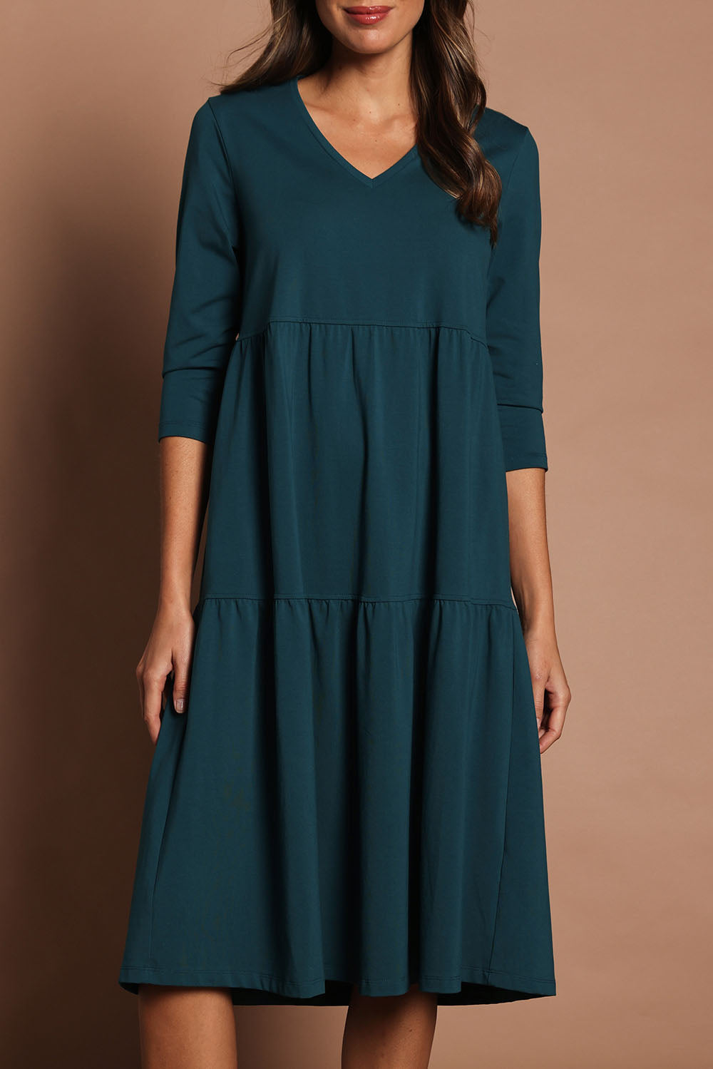 Model Madeline wearing size 10 of The 3/4 Sleeve Tiered Jersey Dress in colour Deepgreen (Green), from the front, cropped image