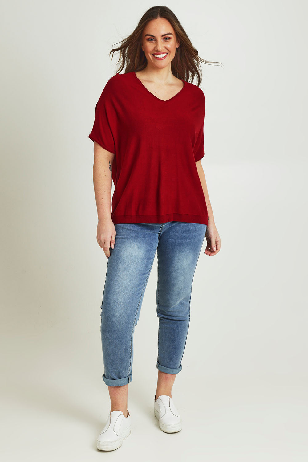 Model Jane wearing size L of The Relaxed V Neck Knit Tee in colour Raspberry (Red), from the front, showing the whole outfit