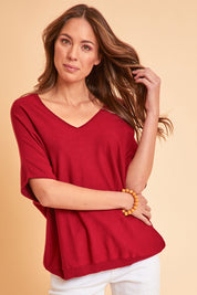 Model Madeline wearing size S of The Relaxed V Neck Knit Tee in colour Raspberry (Red), from the front, showing the whole outfit