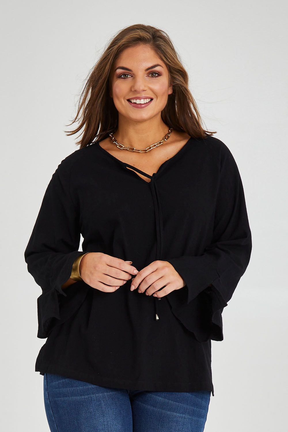 Model Monique wearing size 14 of The Fluted Sleeve Top in colour Black (Black), from the front, cropped image